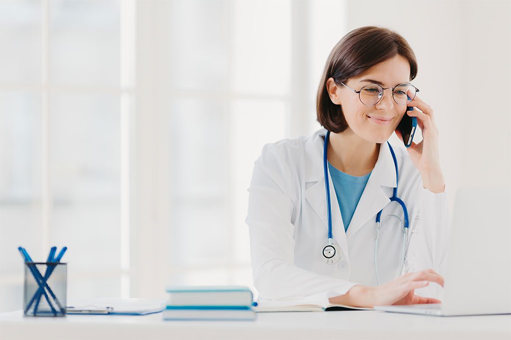 A woman doctor takes a phone call. We offer competitive intelligence services in the healthcare sector.